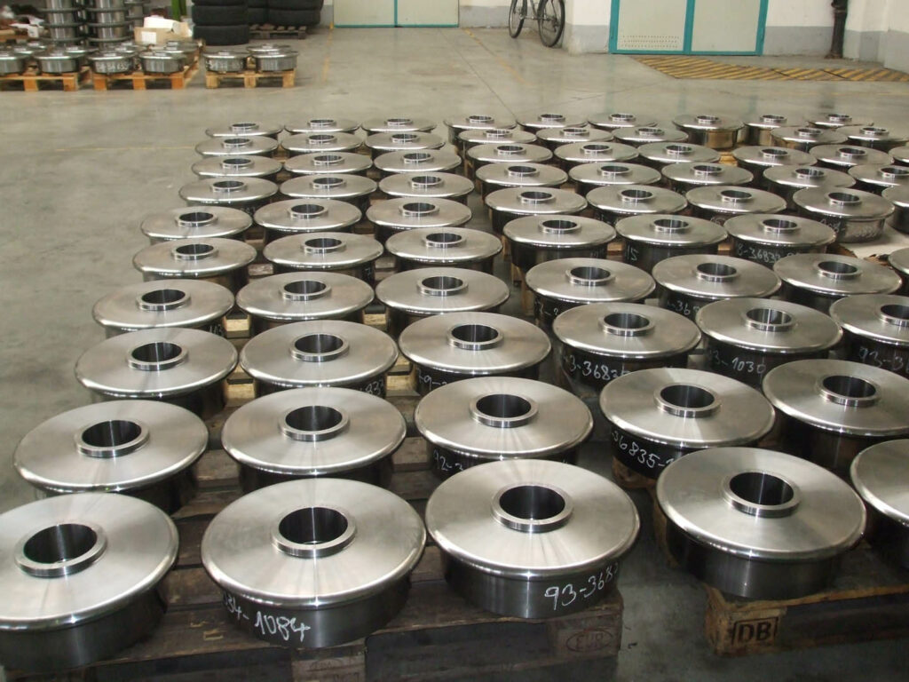 Batch of machined pulley wheels arranged on wooden pallets, ready for delivery.