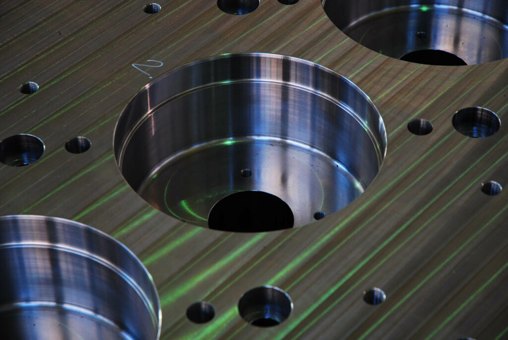 Close-up of deep bored holes in a CNC-machined steel plate