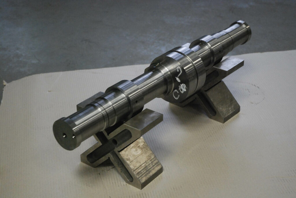 High-precision turned shaft component resting on support fixtures