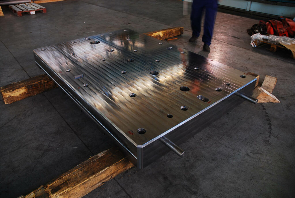 Top view of a polished industrial plate with precision bore holes