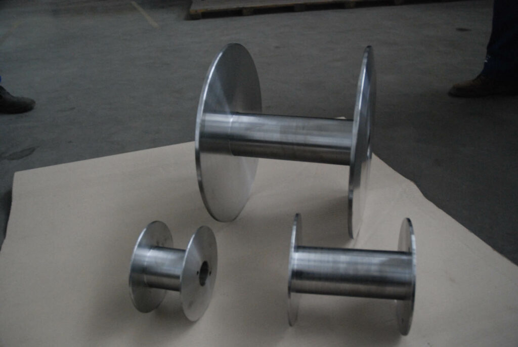 Set of polished cylindrical metal spools for industrial machine use