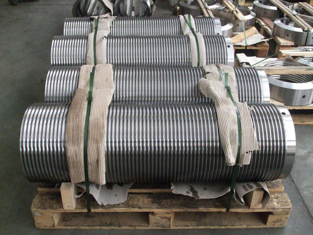 Multiple large threaded shafts with fine machining used in nuclear power plant placed together on a pallet.
