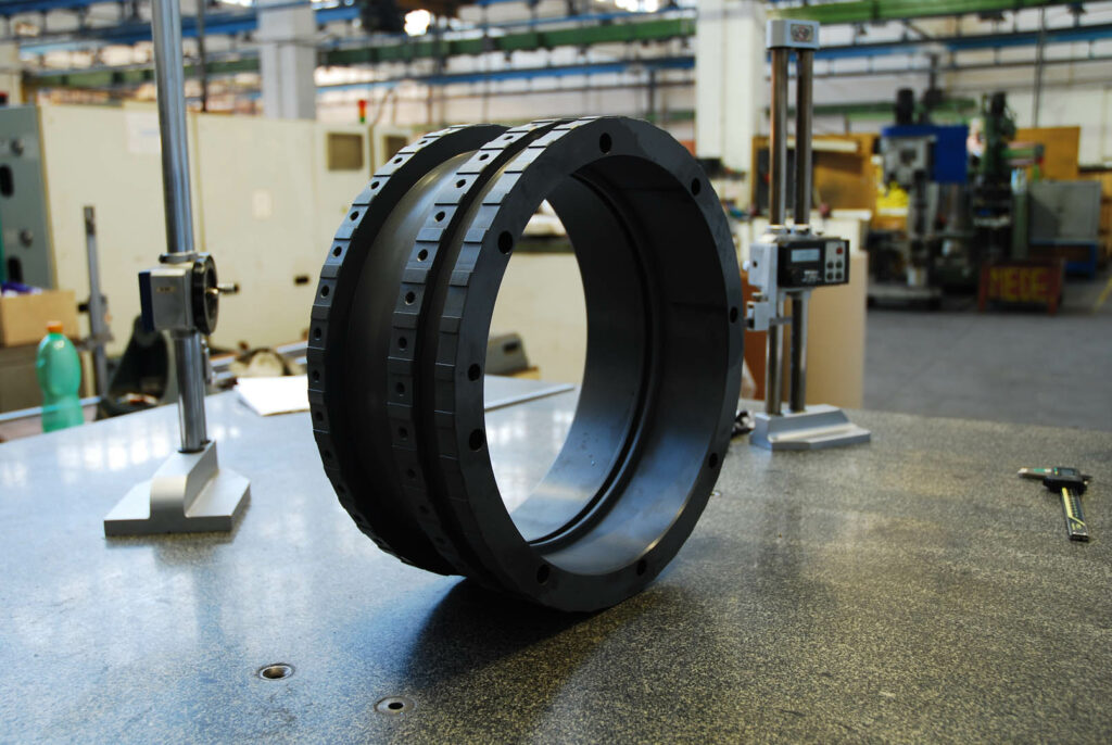Large black coated ring with wide flange used in high-pressure oil and gas assemblies